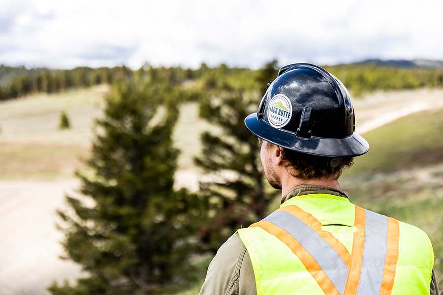 Man wearing hard hat and PPE looking at Montana scenery